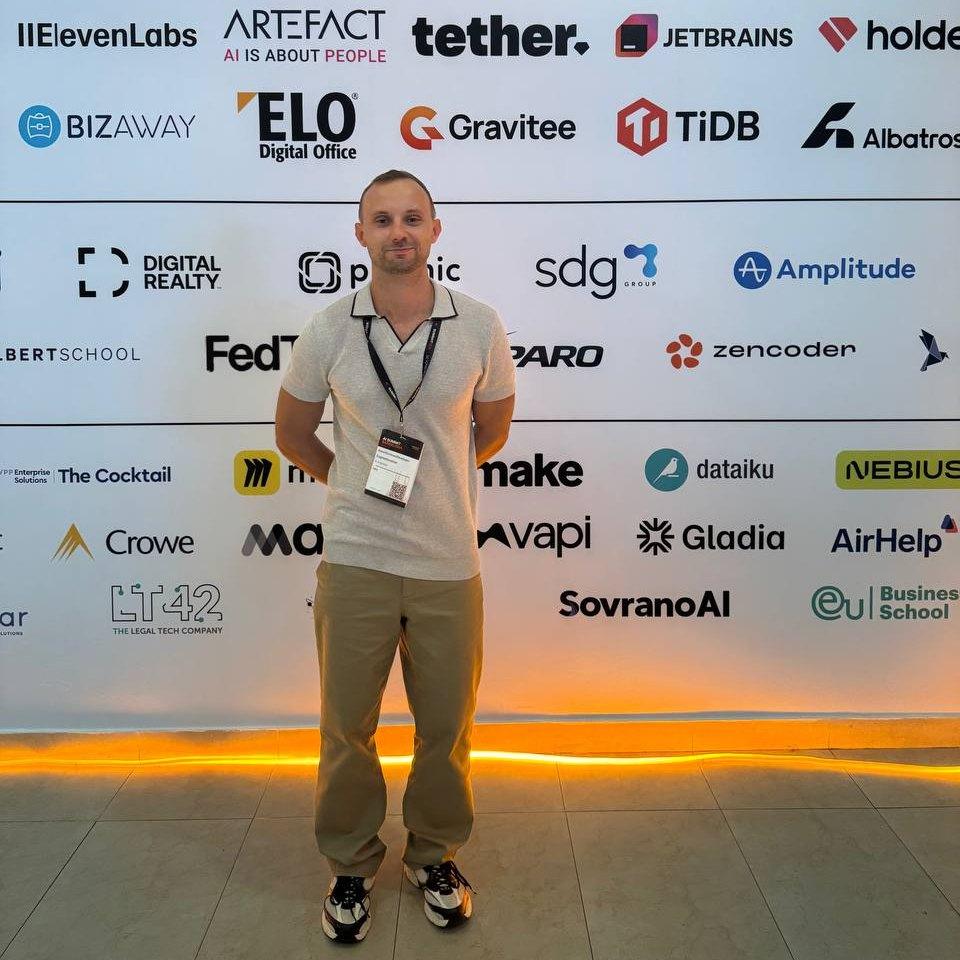 INC4 team member at the AI Summit Barcelona 2026 sponsor wall with logos including Tether, ElevenLabs, JetBrains, Albatross, Nebius and Google